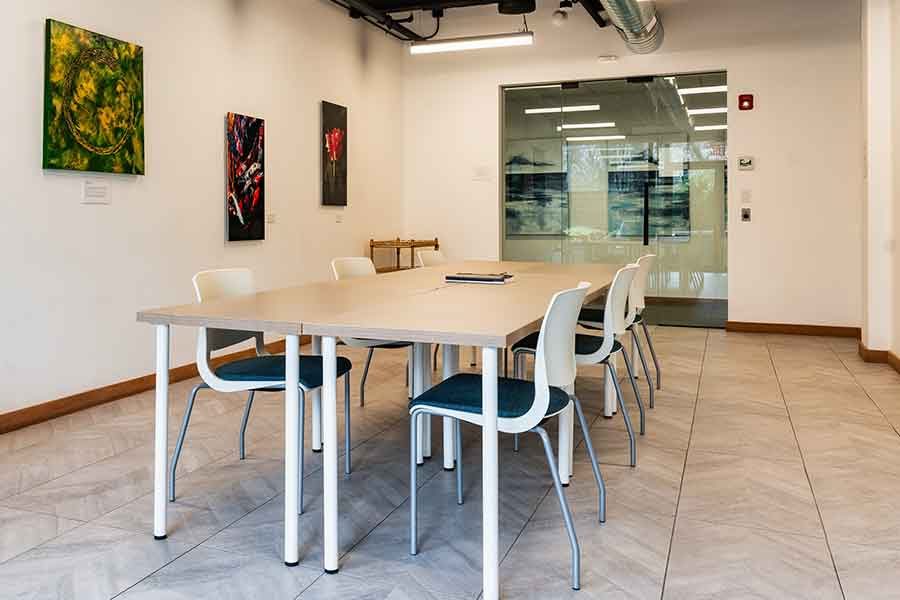 The Creative Cafe at HAYVN Darien laid out for a workshop, with member artwork on the wall
