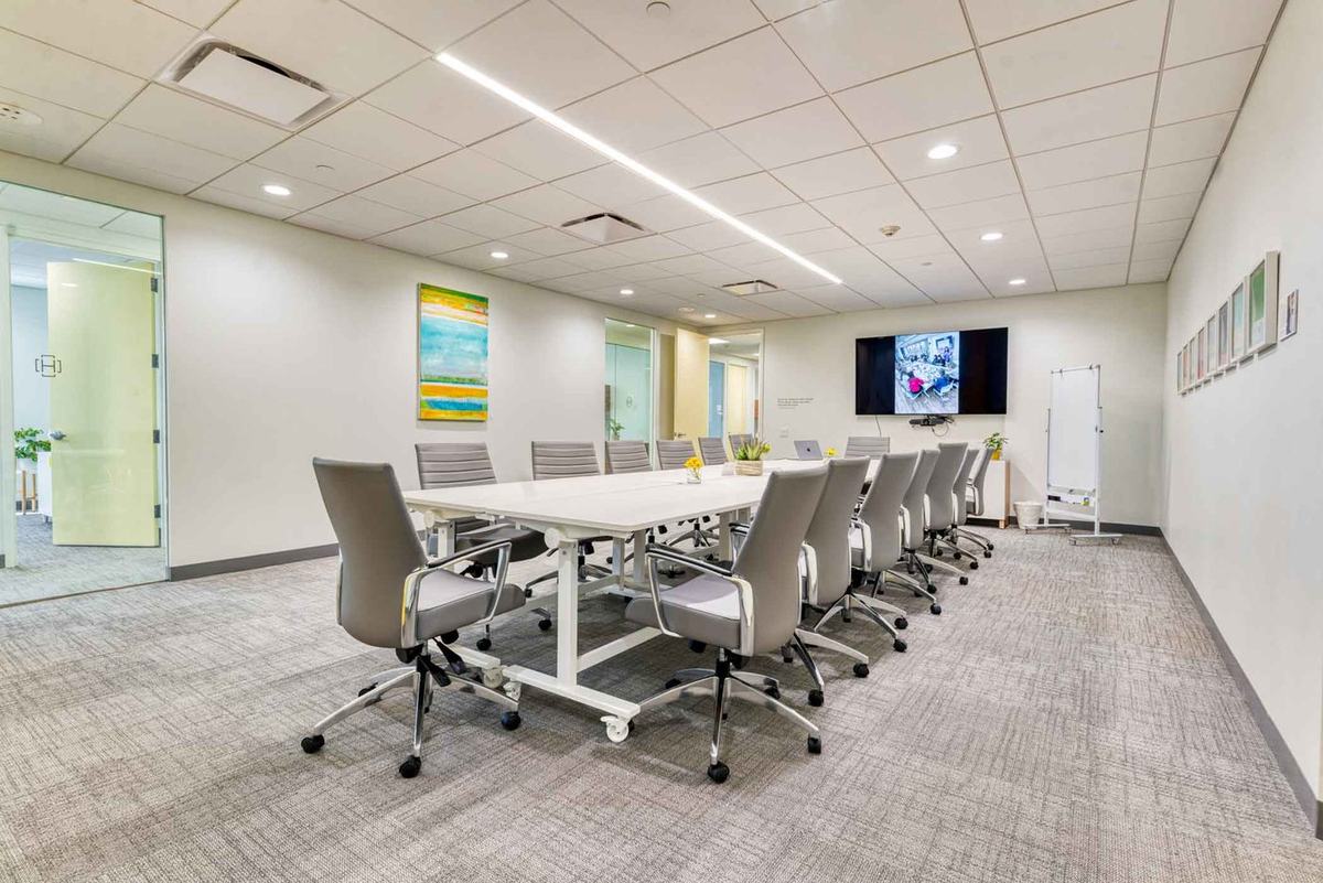 Tod's Point, HAYVN Greenwich: a long white boardroom table with twelve grey chairs, a wall-mounted screen and a whiteboard